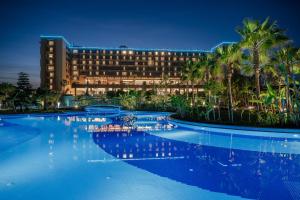 a hotel with a swimming pool at night at Concorde Luxury Resort & Casino in Vokolidha