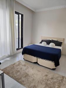 Holistic Balance : غرفة نوم بيضاء مع سرير كبير مع بطانية زرقاء
