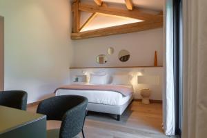 a bedroom with a bed and chairs in a room at Domaine de Panery in Pouzilhac +179 photos