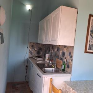eine kleine Küche mit einem Waschbecken und weißen Schränken in der Unterkunft Guest House Torre Guelfa in Figline Valdarno