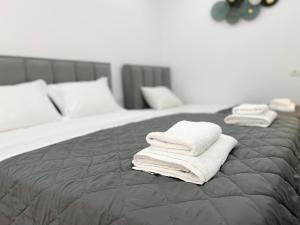 two towels are stacked on top of a bed at Coastal Charm Studio in Himare