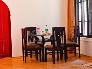奈尼塔爾的住宿－Mansa Home Stay，餐桌、四把椅子和桌子