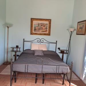 ein Bett in einem Schlafzimmer mit einem Bild an der Wand in der Unterkunft Guest House Torre Guelfa in Figline Valdarno