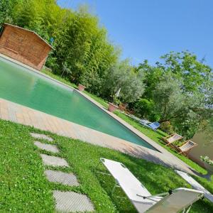 ein Pool mit zwei Liegestühlen im Gras in der Unterkunft Guest House Torre Guelfa in Figline Valdarno
