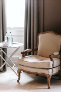 una silla y una mesa junto a una ventana en Murrayfield Hotel en Edimburgo