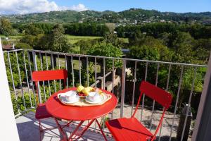 a red table with a plate of fruit on a balcony at Tenuta Castaldi in Santa Maria di Castellabate