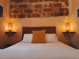 a bedroom with a bed with two lamps on it at Casa Campana in Arcos de la Frontera