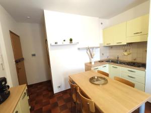 una cucina con tavolo in legno e piano di lavoro di Appartamento Levante vistamare a Caorle