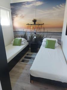 - 2 lits dans une chambre ornée d'une peinture sur la plage dans l'établissement Domki Letniskowe BŁĘKIT, à Gąski