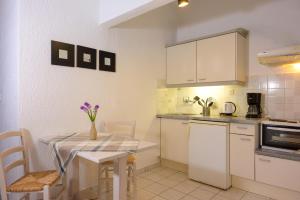 cocina con mesa, mesa y sillas en Havania Apartments, en Agios Nikolaos
