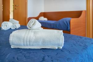 a stack of towels sitting on top of a bed at Nuovo hotel ANTHISA in Lido di Savio +25 photos
