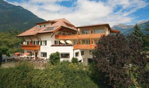 ein großes Haus auf einem Hügel in der Unterkunft Hotel Haselried in Dorf Tirol