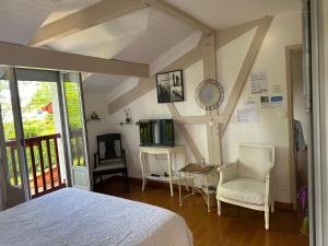a bedroom with a bed and a tv and chairs at LES CHAMBRES D'ARRAUNTZ in Ustaritz