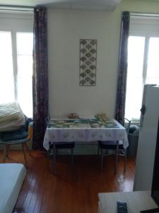 a living room with a table with a table cloth on it at Studio Continental côté jardin in Vittel