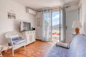 a bedroom with a bed and a tv and a window at Vue exceptionnelle à Saint-Clair pour 4 personnes in Le Lavandou
