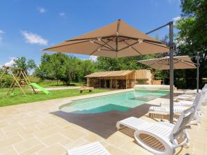 einen Pool mit Stühlen, einem Sonnenschirm und einem Spielplatz in der Unterkunft Spacious farmhouse with private heated pool in a rustic garden in Nantheuil