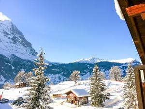 a cabin in the snow with mountains in the background at Apartment Bodmi on the top in Grindelwald