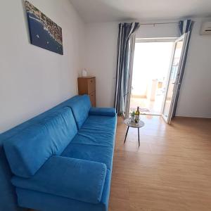 sala de estar con sofá azul y mesa en Apartments Igor, en Bol