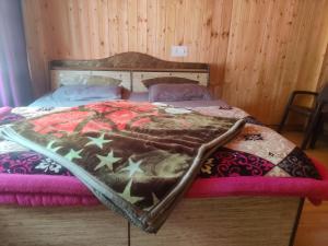 uma cama com uma cabeceira de madeira com estrelas em SURAJ GUEST HOUSE TOSH em Tosh
