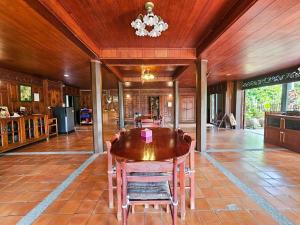 a dining room with a wooden table and chairs at The Thai House Homestay & Thai Cooking Experiences in Ban Bang Sano