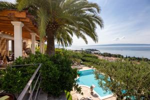 una casa con una palmera y una piscina en Villa Tomislav en Split