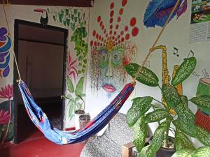 una hamaca azul colgada en una habitación con plantas en The Blues, en Alleppey