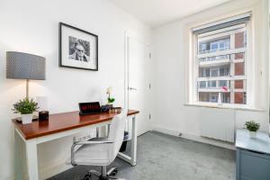 una oficina con escritorio y ventana en Selfridges Parkside Haven - 2 Bedroom Apartment, en Londres