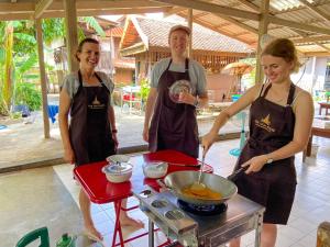 eine Gruppe von Menschen in einer Küche, die Lebensmittel zubereiten in der Unterkunft The Thai House Homestay & Thai Cooking Experiences in Ban Bang Sano
