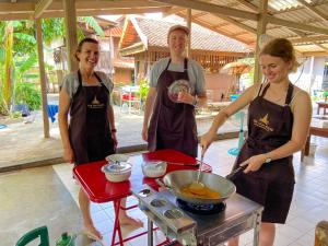 a group of people in a kitchen preparing food at The Thai House Homestay & Thai Cooking Experiences in Ban Bang Sano