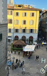 a yellow building with people walking in front of it at La Finestra su San Lorenzo in Florence