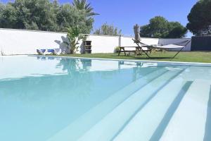 een zwembad met een tafel en een stoel bij Agoodplan Dehesa de El Palmar in Cádiz