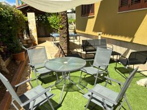 um pátio com uma mesa e cadeiras na relva em Casa Vacanza Mondello em Palermo