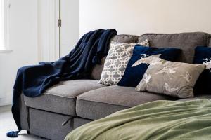 un sofá con almohadas en la sala de estar en Selfridges Parkside Haven - 2 Bedroom Apartment, en Londres