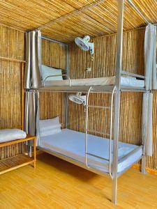 um quarto com três beliches num telhado de palha em Tuan Ngoc Hotel em Ninh Binh