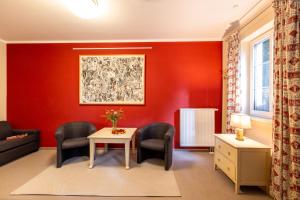 sala de estar con paredes rojas, mesa y sillas en Café Wildau Hotel & Restaurant am Werbellinsee en Schorfheide