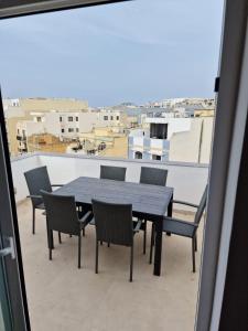 a table and chairs on a balcony with a view at Sky Apartment 3 in St Paul's Bay