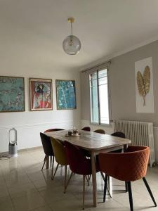 Maison 20 min de PARIS : غرفة طعام مع طاولة وكراسي خشبية