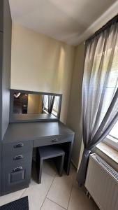 einen Schreibtisch in einem Zimmer mit einem Spiegel und einem Fenster in der Unterkunft Sonnenseite in Laboe