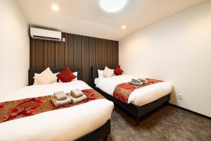 a hotel room with two beds with towels on them at 84-5, Shiomi 301, Entire room for rent in Tokyo