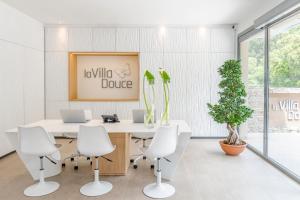 an office with a white desk and white chairs at Hôtel La Villa Douce in Rayol-Canadel-sur-Mer