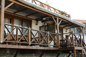 a house with a wooden porch with a balcony at MAVİ AT HOTEL Blue Horse in Gümüşdere