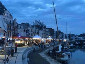 ラ・ボールにある3Très Beau logement, idéalement situé , Plages, Port & Vélo à Dispの夜に港を歩く人々のグループ