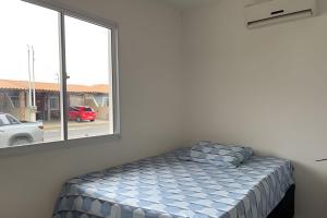 uma cama num quarto com uma janela em Casa condomínio fechado. em Petrolina