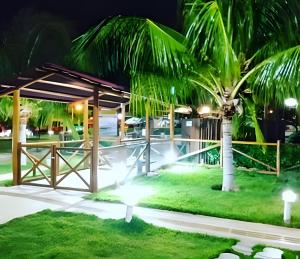 a resort with a palm tree at night at Casa condomínio fechado. in Petrolina