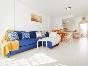a living room with a blue couch and a table at Sunny Blue Home - near Pools, Beach and Golf in Los Alcázares