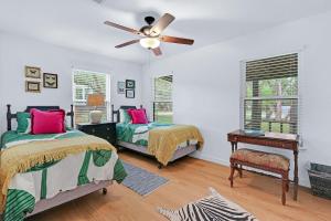 a bedroom with two beds and a ceiling fan at The Vagabond in Wimberley