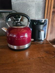 a red tea kettle on a table next to a cup at MAVİ AT HOTEL Blue Horse in Gümüşdere