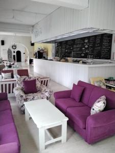 a living room with purple couches and a counter at Esperides Hotel in Myrtos