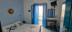 a bedroom with a bed and a door to a patio at Studio Elisabeth in Agios Ioannis