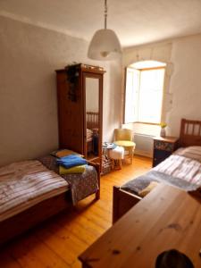 uma sala de estar com duas camas e um espelho em Le Chai, Chateau de Charras, Family Friendly Holiday Destination em Charras